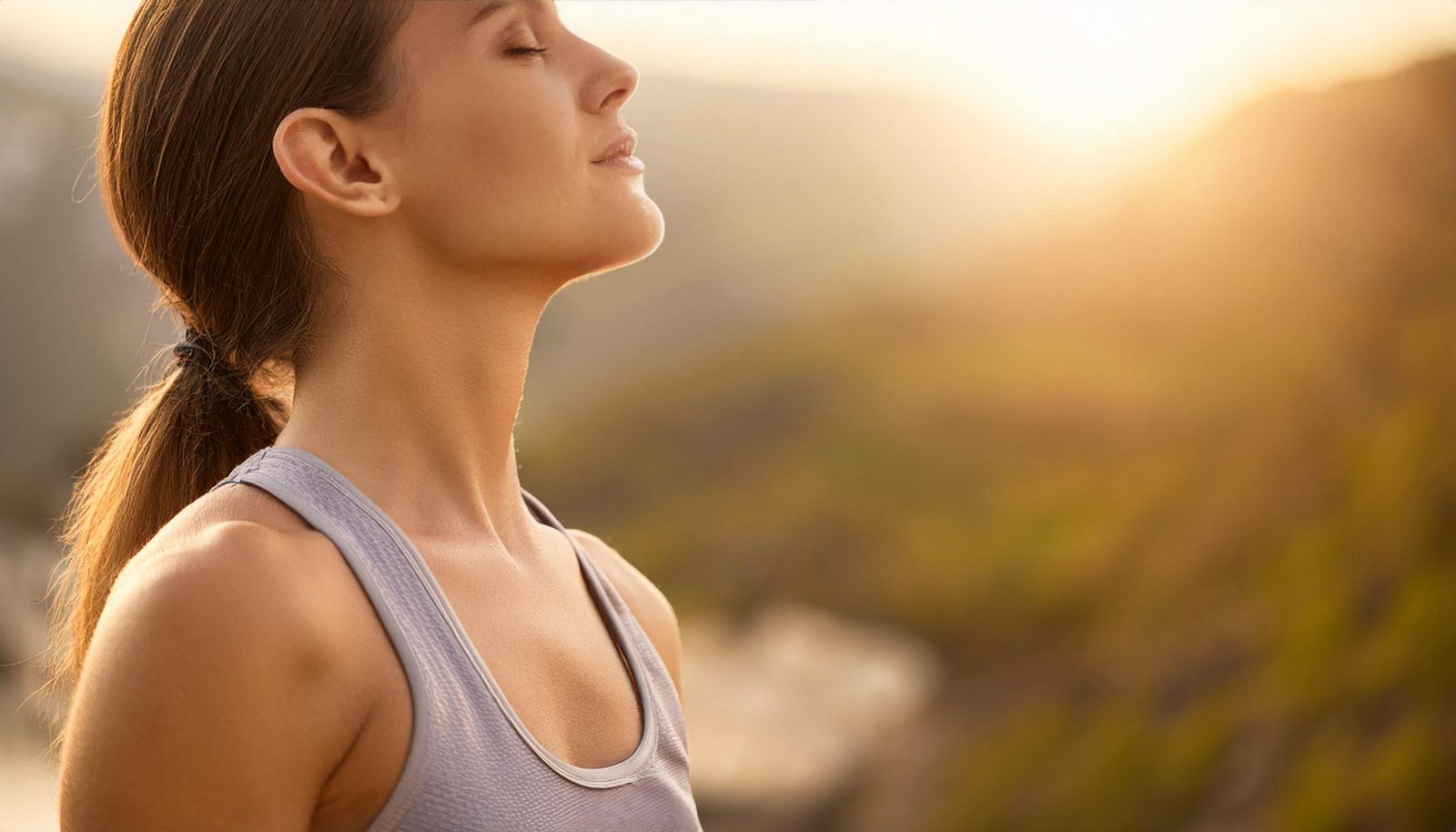 A person resting while their breathwork facilitator offers gentle support